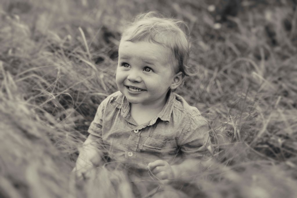 Close-up picture of a young boy sitting in grass