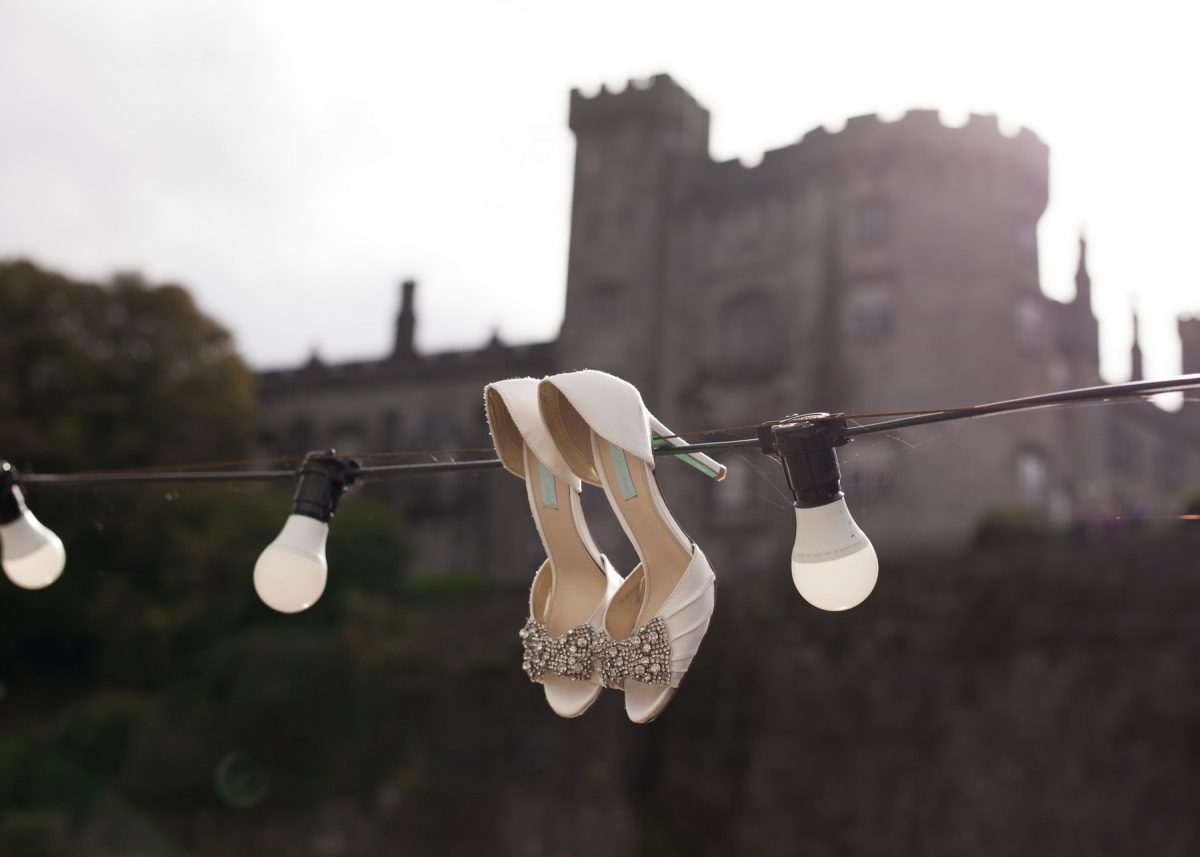 Wedding shoes hanging on wire with Kilkenny castle in background