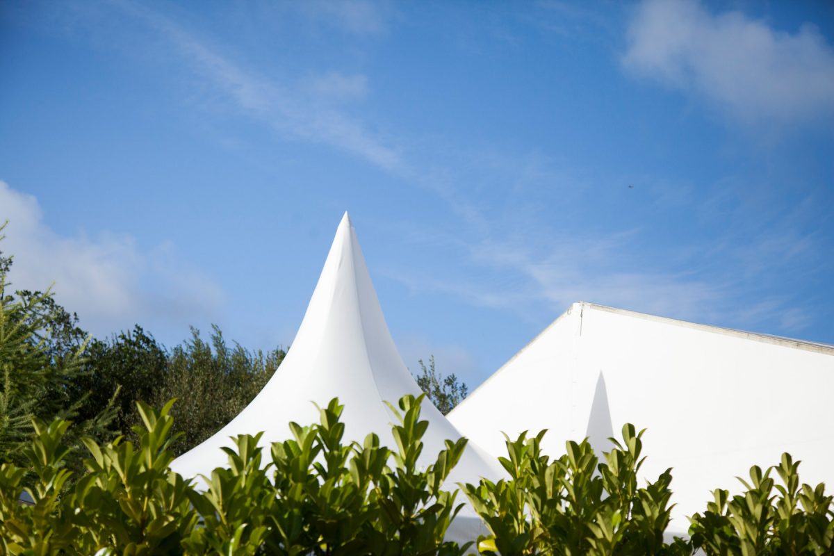 Photograph of the tops of tents with the blue sky in background