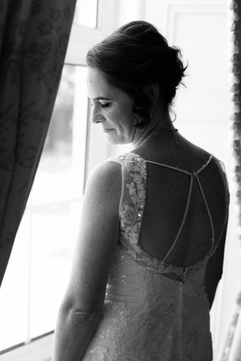 Black-and-white photo of a bride looking out the window