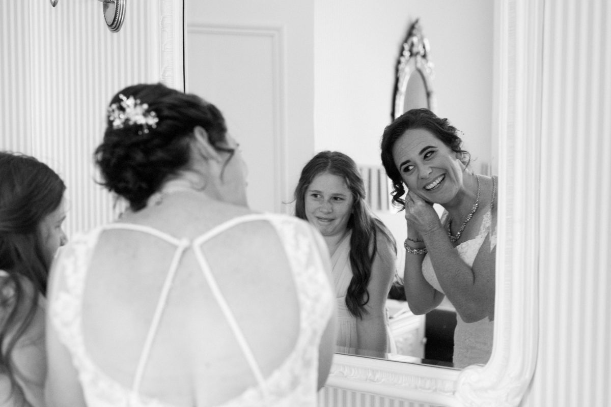 Reflection of the bride putting in her earrings